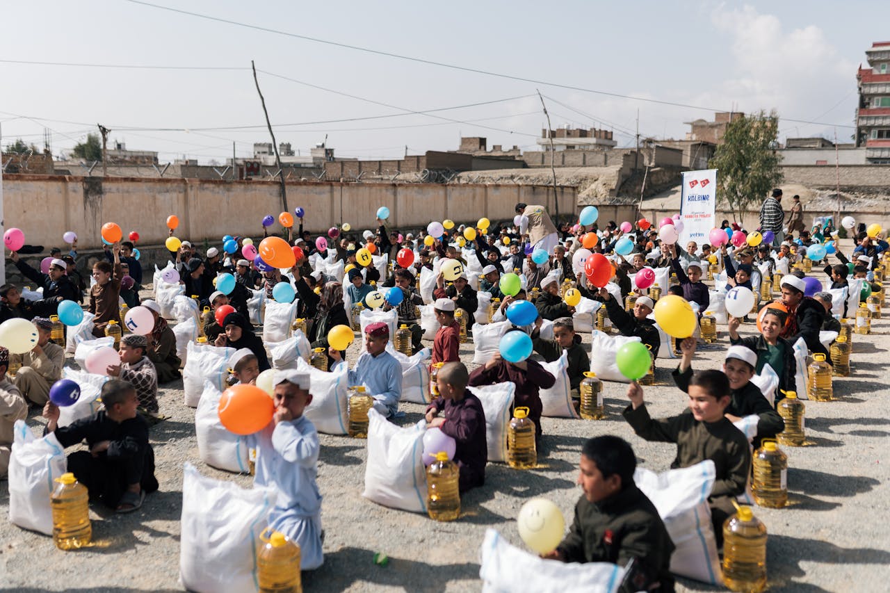services-03 Children gather with balloons and supplies during a daytime event in Afghanistan.