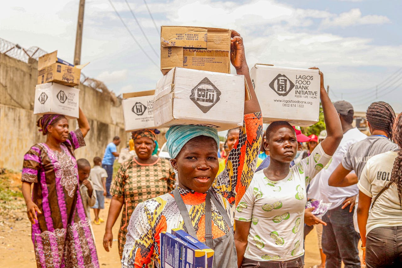 hero-img-02 People carrying charity boxes during a community distribution event in Lagos.